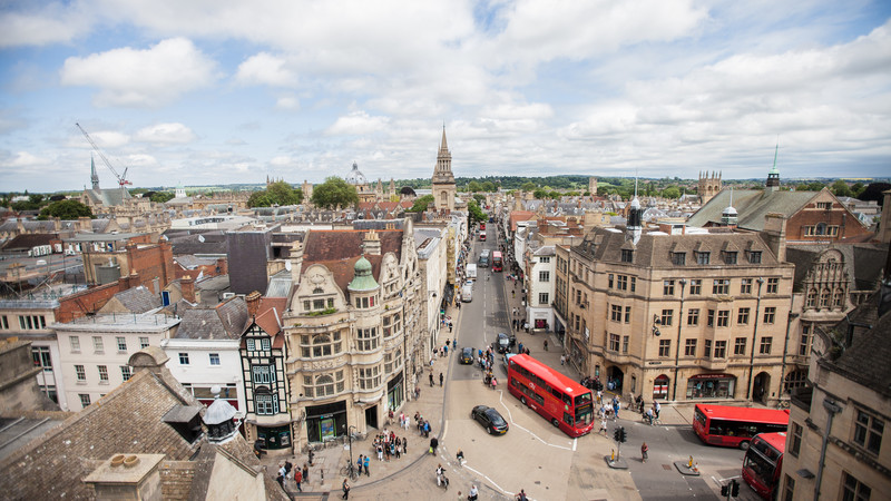 Aerial view of Oxford city centre from Carfax Tower with red buses travelling along High Street